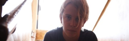 Tom Odell sitting on stairs